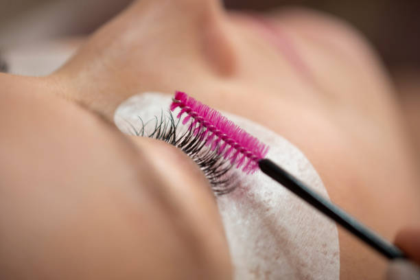 Close-up of the insertion of artificial eyelashes Close-up of the insertion of artificial eyelashes with tweezers in the cosmetic studio, eyelash extension in the cosmetic studi lash and brow comb stock pictures, royalty-free photos & images