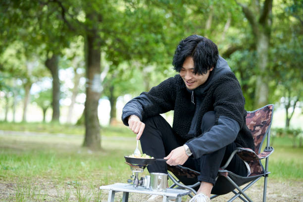 istock A young Japanese man cooking alone in a camp 1249745677