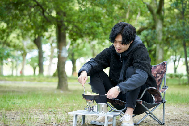 istock A young Japanese man cooking alone in a camp 1249745688