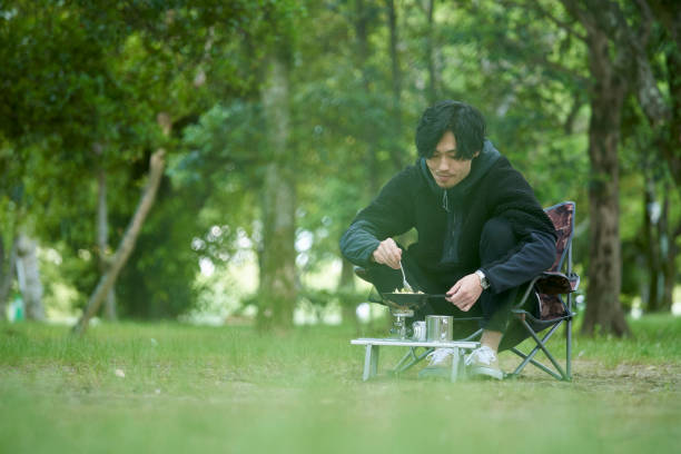 istock A young Japanese man cooking alone in a camp 1249745732