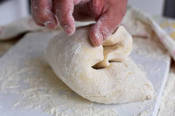 istock Bread making process. Closeup of man hands kneading dough. Baker cooking pastry. Culinary courses and food preparation. 1249747475