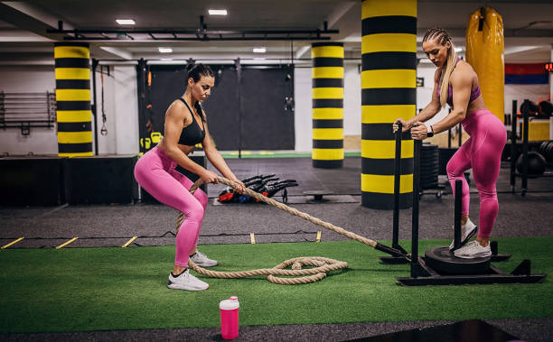 istock Two beautiful fit women exercising in gym together 1249749764