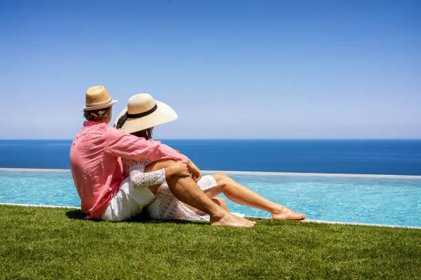 istock A vacation couple with sunhats sits hugging by the pool 1249750847