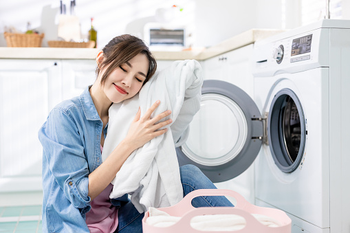 Asian housewife wash clothes happily  at home
