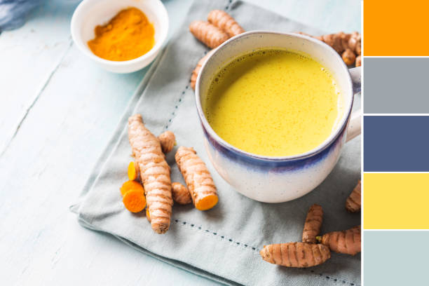 Golden turmeric milk drink in mug. Color swatch Golden turmeric coconut milk drink in mug on pastel background. Color swatch food sample cups stock pictures, royalty-free photos & images