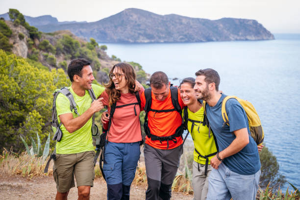 istock Laughing hikers embracing on Mediterranean coastal trail 1249756201