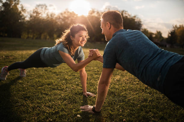 istock Happy athletic couple cooperating while exercising strength in nature. 1249756342