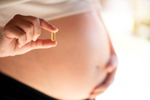 happy pregnant woman showing medicine - herbal medicine vitamin pill capsule nutritional supplement imagens e fotografias de stock