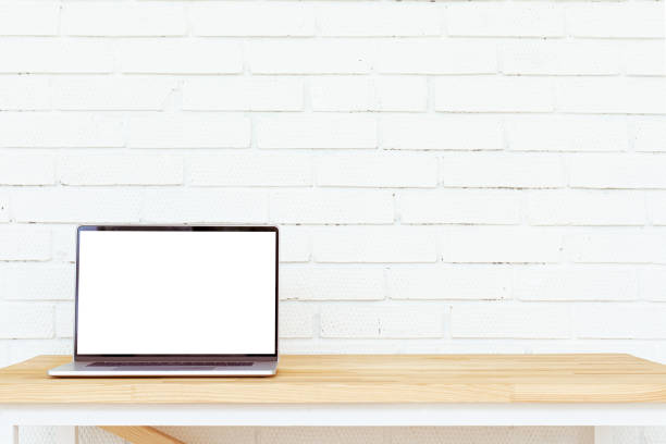 Laptop with white blank screen on wooden table. Open space.