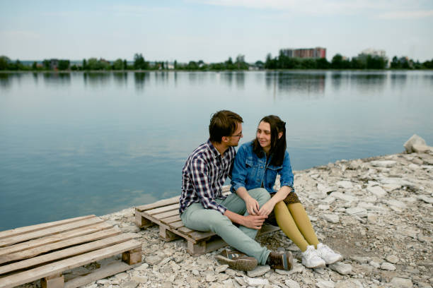 istock Romantic young couple sitting be the lake 1249757272