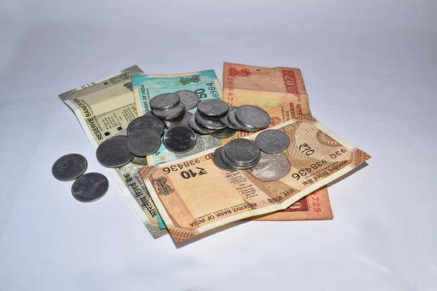 istock Pile of Indian Currency notes and coins on white background. Artistic blur effect applied. 1249757402