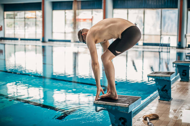 istock Young man with disability preparing for jump in swimming pool 1249758443