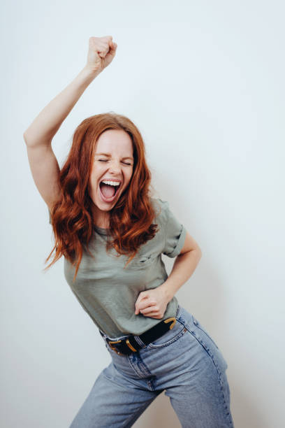 istock Excited triumphant young woman cheering 1249758800