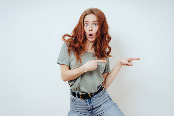 istock Playful young woman pointing to the side 1249758801