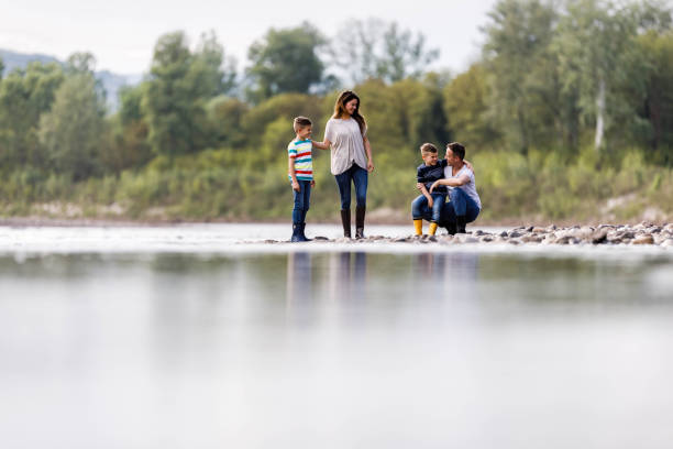 istock Happy family talking while enjoying by the riverbank. 1249759033