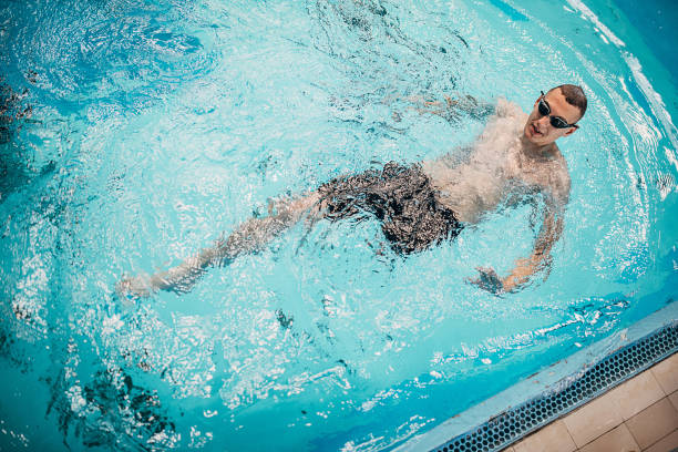 istock One man with disability swimming in swimming pool indoors 1249759420