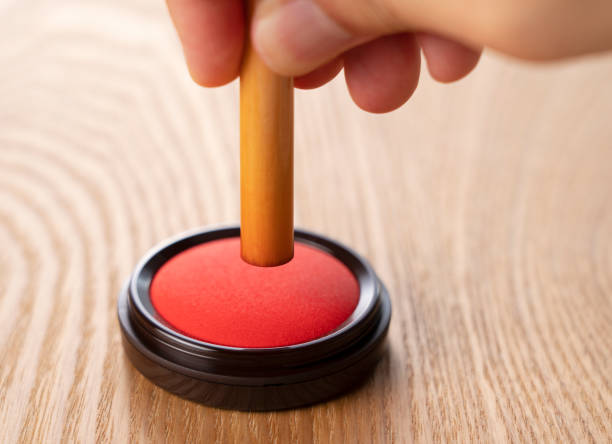 istock Pressing a seal on a red ink on a wooden background 1249760150