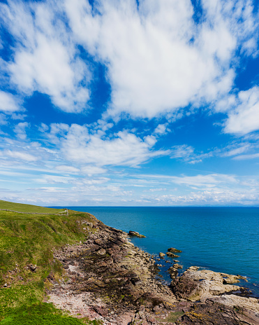 Aerial view of the rugged coast of the Solway Firth in Dumfries and Galloway.\nThe vertorama was created by merging two images.\nThe image was captured by a drone on a bright summer day.\nThis section of the coast has a popular coast walk.