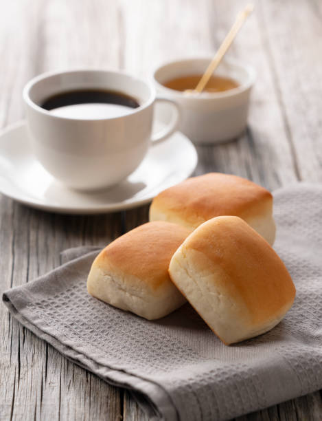 istock Dinner rolls, coffee and honey set against an old wooden backdrop. Breakfast Image. 1249760713