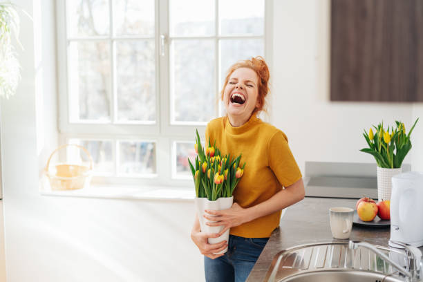 young woman laughing holding a vase of tulips - tulip vase flower spring imagens e fotografias de stock