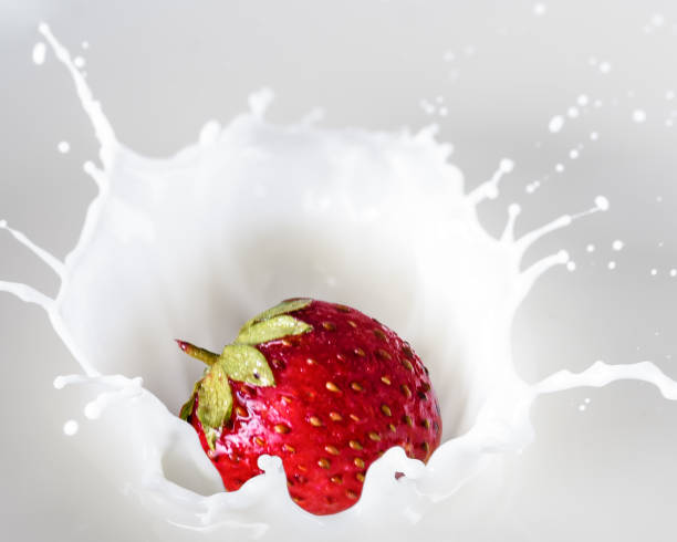 istock strawberries fall into the cream with a splash 1249761047