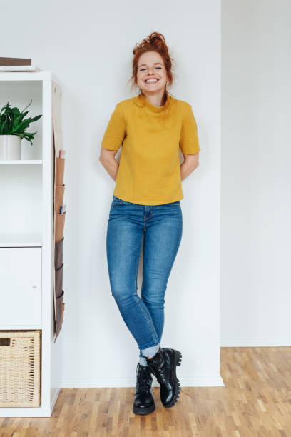 istock Young woman smiling, standing at white wall 1249761053