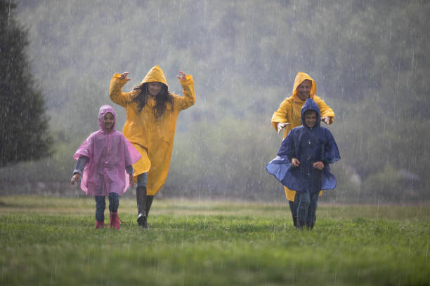 istock Young carefree family having fun while chasing on rain in nature. 1249762211