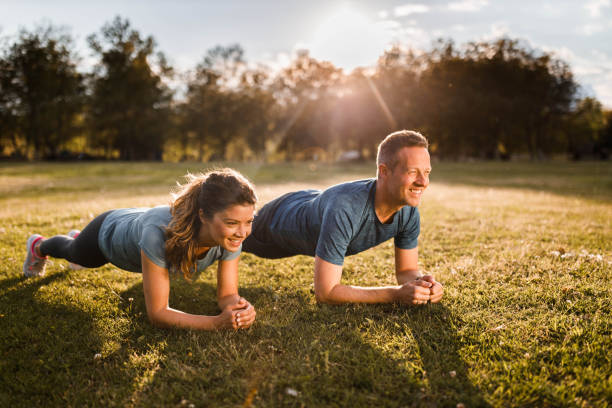 istock Happy athletic couple in plank position at the park. 1249762306