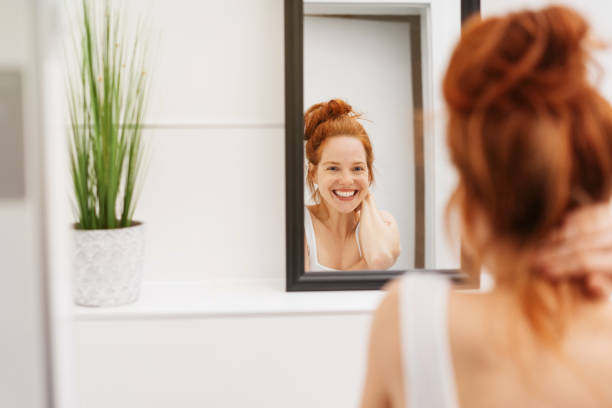 istock Happy young woman grinning at her reflection 1249763400
