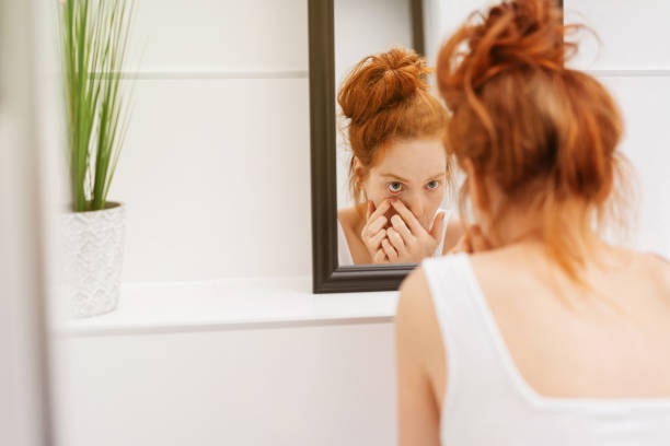 istock Young redhead woman applying makeup 1249763444