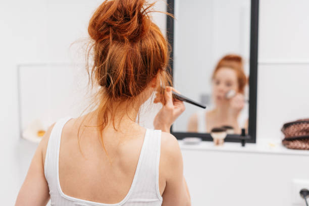 istock Rear view of a young woman applying makeup 1249763494