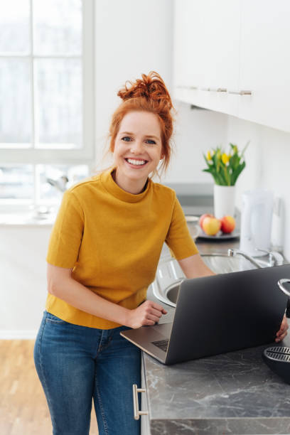 istock Smiling happy young woman relaxing in her kitchen 1249763557