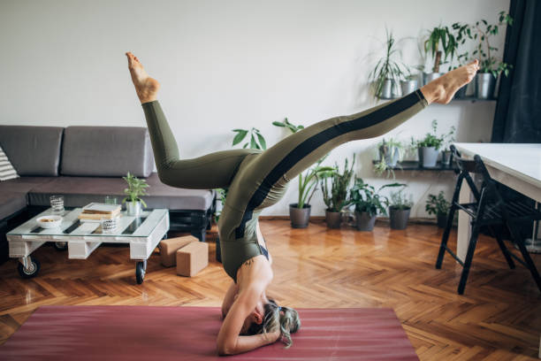 istock Young woman in headstand pose 1249768110