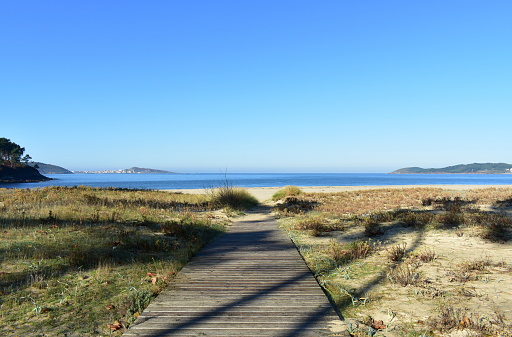 Atlantic Ocean, Rias Altas, Muxia, A Coruña Province, Galicia Region, Spain, Europe. Morning view of a Idyllic beach on a bay with blue sky.