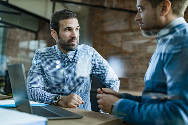 istock Male entrepreneurs talking while working on laptop in the office. 1249772710