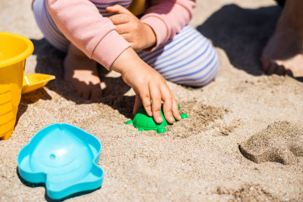 padre e hija felices juegan en la arena en la playa. - sandbox child human hand sand fotografías e imágenes de stock