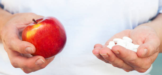 istock Apple and many pills in the hands 1249773639