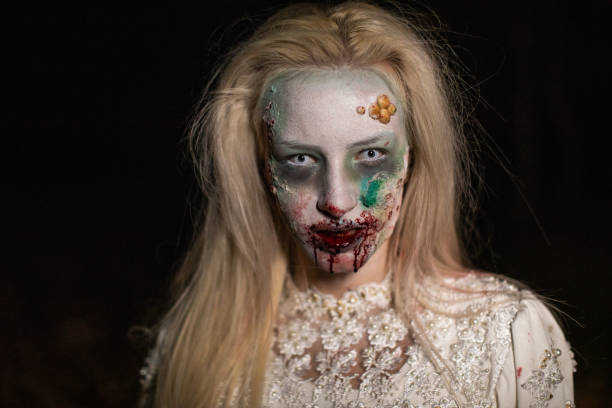 istock Female vampire with bloody lips after biting victim 1249775551