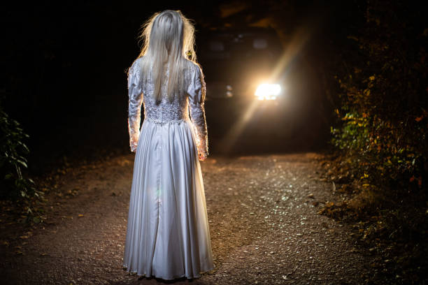 istock Witch in wedding dress standing on a road at night 1249775562