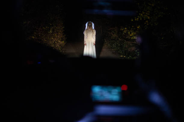 istock Witch in wedding dress standing on a road at night 1249775789