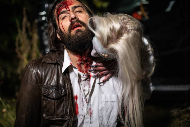 Zombie biting young man's neck in forest at night Female zombie with white hair biting young man's neck in forest at night male vampire biting his victim stock pictures, royalty-free photos & images