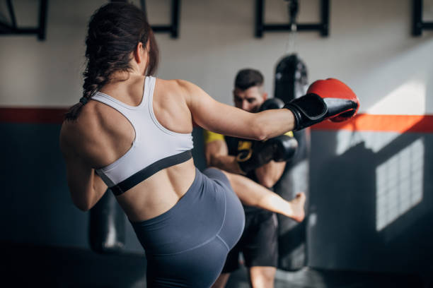istock Woman kickboxer sparring with her coach 1249777128