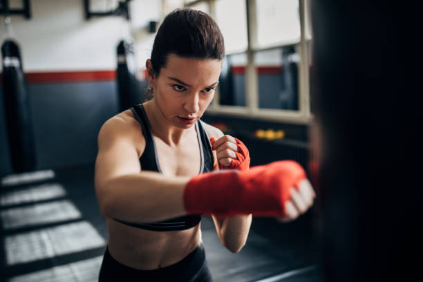 istock Woman kickboxer punching a punching bag 1249777233