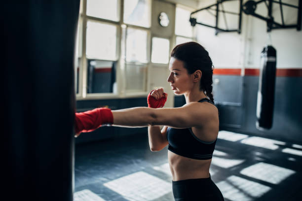 istock One young woman kickboxer punching a punching bag 1249779123