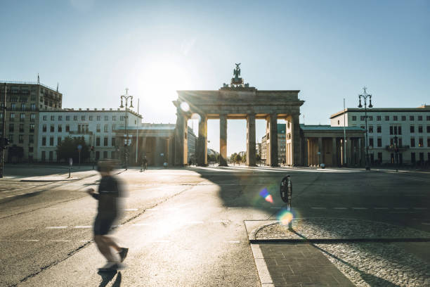 runner passing in front of Brandenbuger Tor in berlin in the morning light