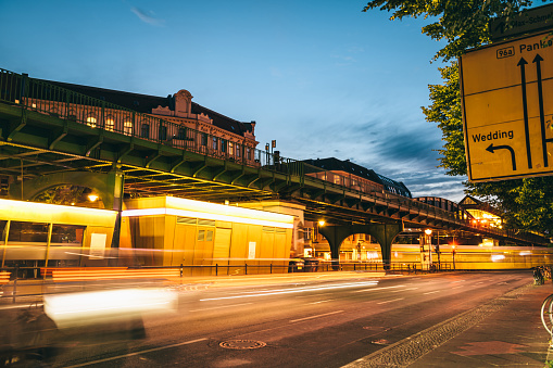 long exposure of yellow street car under metro bridge in Berlin Prenzlauer Berg at night