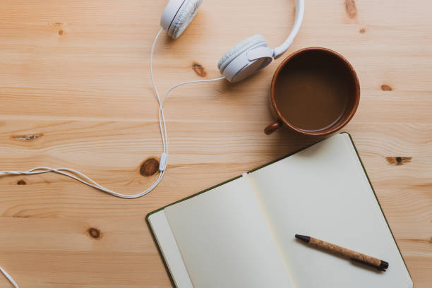 istock Peaceful workspace with headphones melted chocolate and a notebook over a natural pine table. Inspiration moment. Detail. 1249782942