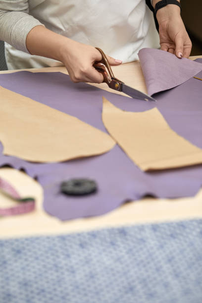 istock female hand with the scissors cutting fabric. 1249787776