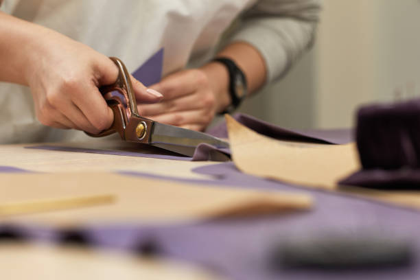 istock female hand with the scissors cutting fabric. 1249788018