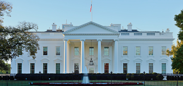 Daytime panoramic view of the northern facade of the white house featuring its classical portico with columns. The White House - US president’s official residence - is located at 1600 Pennsylvania Avenue. The neoclassical building - built between 1792 and 1800 - has been the residence of all U.S. President since John Adams.